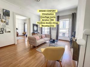a living room with a couch and a chair at Escale citadine au centre d'Avignon, climatisation, appartement de charme, spacieux et lumineux in Avignon