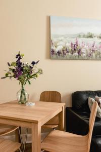 a dining room table with a vase of flowers on it at Sea Sound in Cellardyke