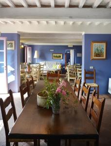 une salle à manger avec une table en bois et des fleurs. dans l'établissement Casa Fontanino, à Altopascio
