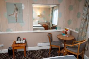 Zimmer mit einem Spiegel, einem Tisch und einem Bett in der Unterkunft Bridge Inn in Clevedon
