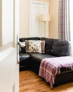 a black leather couch in a living room at Sea Sound in Cellardyke