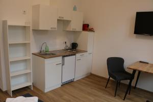a kitchen with a sink and a table and a chair at Riverside Apartments in Linz