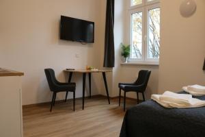 Habitación con mesa, sillas y TV. en Riverside Apartments, en Linz