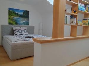 Dormitorio pequeño con cama y estante de libros en Ferienwohnung BergTime, en Weißenbach bei Liezen