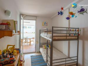 a bedroom with two bunk beds and a dining room at Apartamento Sky Blue in Colònia de Sant Jordi