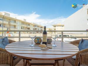 a table with a bottle of wine and two glasses at Apartamento Sky Blue in Colònia de Sant Jordi