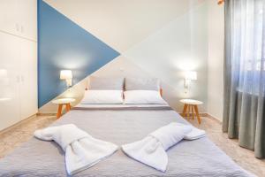 duże łóżko w pokoju z dwoma stołami w obiekcie Catherine Blue Suites - 4 minutes off the Beach w mieście Poros