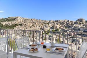 a table with plates of food on top of a city at Itria Modica in Modica