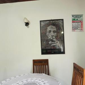 a picture of a man on a wall with two chairs at Jimmy House in Aluthgama