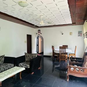 a living room with couches and chairs and a table at Jimmy House in Aluthgama