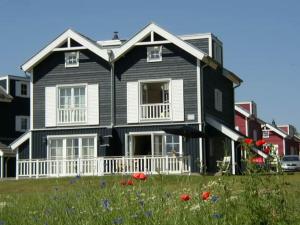 a black and white house with a field of flowers at Ferienhaus Meerblick in Sierksdorf