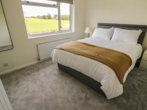 a bedroom with a large bed with a large window at Field View in Newport