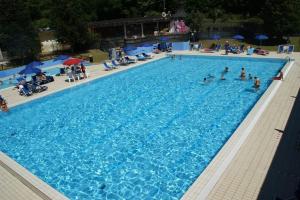 a large swimming pool with people in the water at Gli Aristogatti in Campo Tizzoro