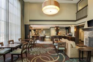 a hotel lobby with tables and chairs and a fireplace at Staybridge Suites Columbus-Dublin, an IHG Hotel in Dublin