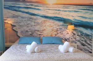 a bedroom with a painting of the ocean at Pension Zandvoort aan Zee in Zandvoort