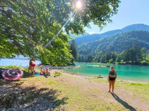 a woman standing on a beach near a body of water at Bovec Garni Apartment 7 in Bovec