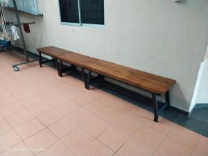 a wooden bench sitting against a wall at D' SHAM Homestay, Mslim Only in Kulim