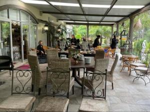 un patio con mesa y sillas y gente sentada alrededor de él en Palm Villa, en Sunlands