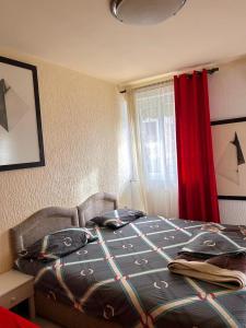 ein Schlafzimmer mit einem Bett und einem roten Vorhang in der Unterkunft Apartmani Vila Marija in Budva