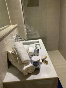 een badkamer met een wastafel, handdoeken en een spiegel bij Appartement neuf climatisé, centre Marrakech. in Marrakesh