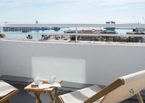 a balcony with chairs and a view of a harbor at Living4malaga Atico Marina in Málaga