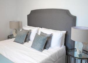 a white bed with pillows on it with two lamps at Living4malaga Atico Marina in Málaga