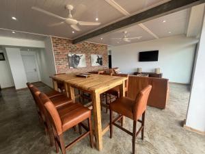 a dining room with a wooden table and chairs at Mitford The N I C E Condo in Morganʼs Bay