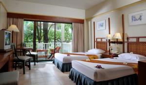 ein Hotelzimmer mit 3 Betten und einem Balkon in der Unterkunft Karon Princess Hotel SHA EXTRA Plus in Karon Beach + 20 Fotos