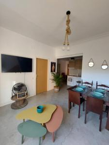 a living room with a table and chairs and a tv at Sara's apartment Barcelona in El Prat de Llobregat