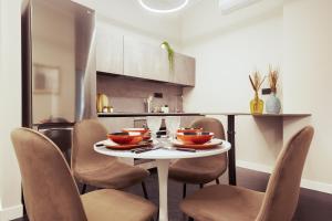 a kitchen with a table and chairs with bowls on it at HL Luxury Apartment - Duomo, Galleria Unione 5 in Milan