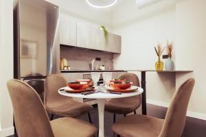 - une cuisine avec une table et des chaises avec des bols dans l'établissement HL Luxury Apartment - Duomo, Galleria Unione 5, à Milan