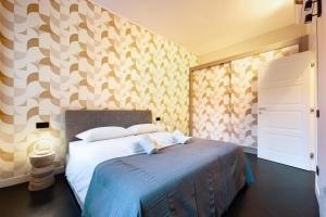 - une chambre avec un lit et un mur aux motifs géométriques dans l'établissement HL Luxury Apartment - Duomo, Galleria Unione 5, à Milan 9 autres photos