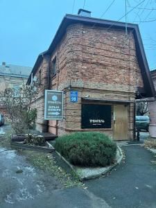 ceglany budynek z napisem na boku w obiekcie Міні-готель Тремпель w Charkowie