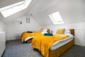 two beds in a room with white walls at Impeccable 3-Bed House in Abbeywood in London