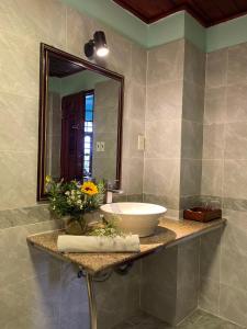 un baño con lavabo y espejo en Ca Ty Hotel, en Phan Thiet
