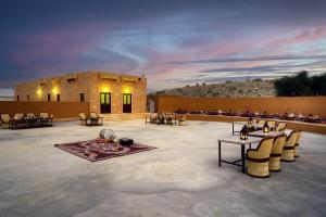 ein Gebäude mit Tischen und Stühlen davor in der Unterkunft Desert Vista Camp in Jaisalmer