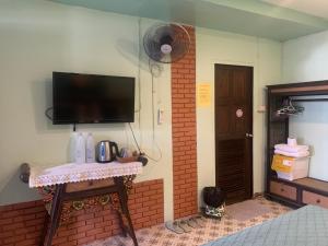 a room with a tv on a wall with a table at Dream Garden Villa Hotel Night Bazaar ChiangMai in Chiang Mai