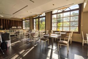 Un restaurante con mesas, sillas y ventanas. en Hotel Blancafort Spa Termal, en La Garriga