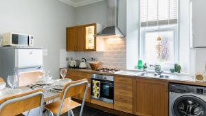 a kitchen with a sink and a table with chairs at Sea Breeze in Anstruther