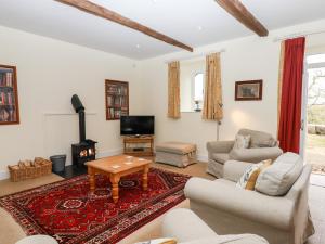 een woonkamer met een bank en een tafel bij Dishcombe Cottage in Okehampton