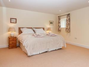a bedroom with a large bed and a window at Dishcombe Cottage in Okehampton