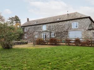 een oud stenen huis met een tuin bij Dishcombe Cottage in Okehampton