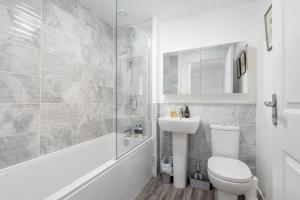 a white bathroom with a toilet and a sink at Fort Avenue - No 31 Guardbridge in Guardbridge +8 photos