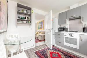 a kitchen with white cabinets and a glass table at Fort Avenue - No 31 Guardbridge in Guardbridge