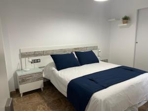 a bedroom with a large bed with blue pillows at Torre del reloj - Parking gratis in Cazorla