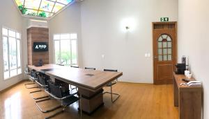 a conference room with a large wooden table and chairs at Nap Hotel in Ponta Grossa