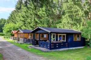 a blue cabin in front of a forest at Camping Lotje in Elbingerode