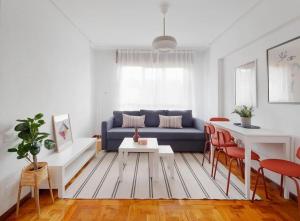 un soggiorno con divano blu e sedie rosse di Apartamento Maura 2 dormitorios a Oviedo