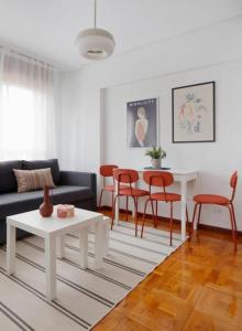 sala de estar con sofá, mesa y sillas en Apartamento Maura 2 dormitorios, en Oviedo