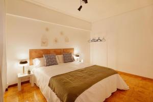 1 dormitorio con 1 cama grande en una habitación blanca en Apartamento Maura 2 dormitorios, en Oviedo